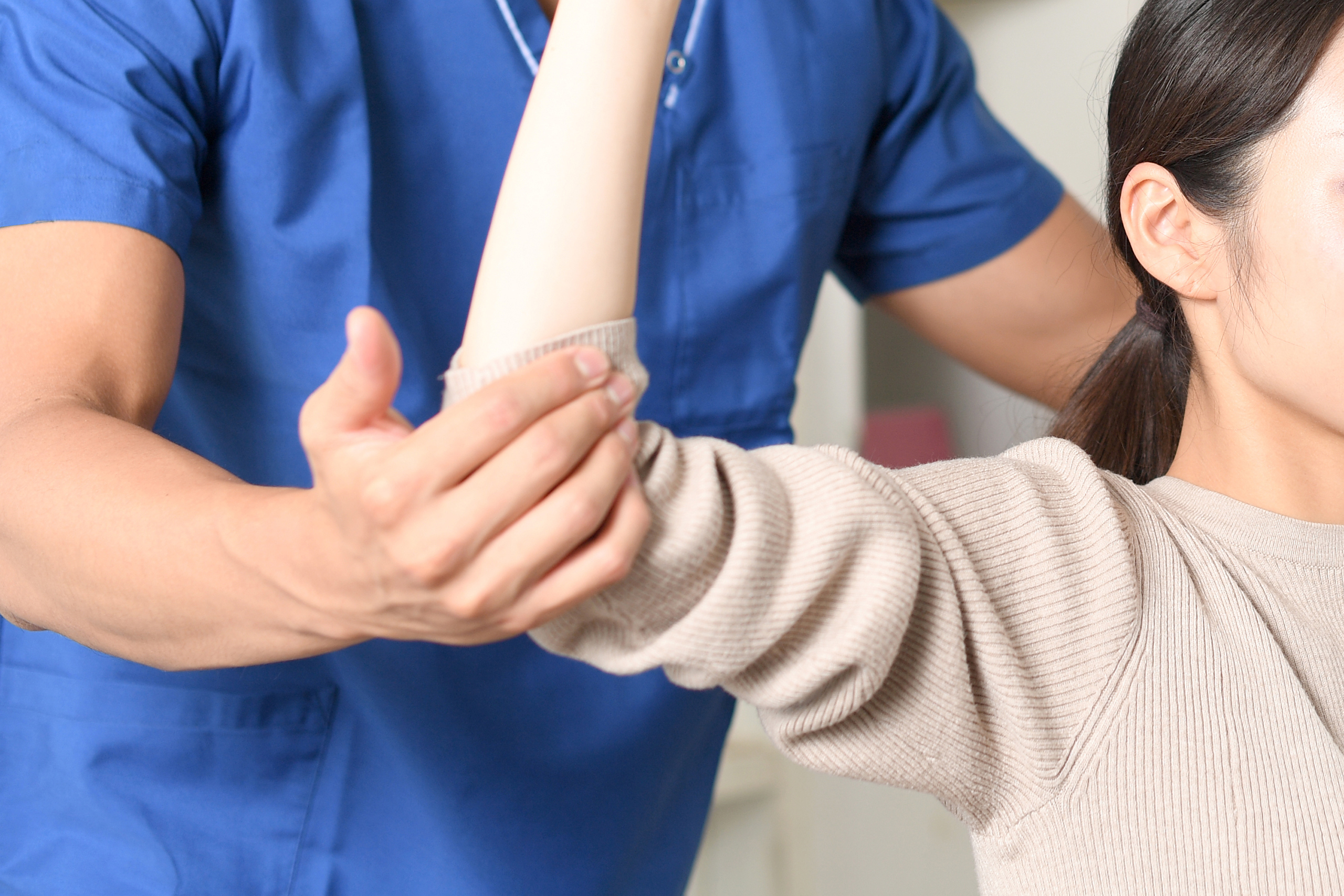 上半身のマッサージをするスクラブを着た整体